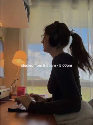 A woman in a study setting, side-profile view, wearing glasses and headphones, typing on a keyboard. Daylight pours through the window illuminating the space and highlighting the text overlay.