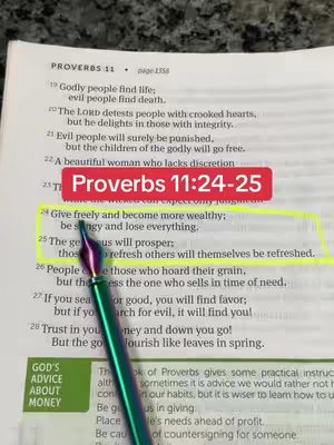 The image shows an open Bible with text highlighted. A red rectangle contains the text "Proverbs 11:24-25". A pen with purple ink is placed on the Bible.