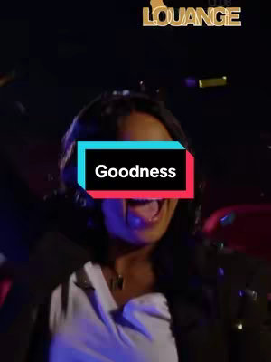 A woman with dark hair and a white top is in a dark setting. A rectangular overlay is centered over her face, reading "Goodness" in white text with a black background, bordered by a teal above and red below.