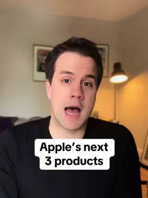 The cover image features a man with dark hair and a black shirt looking directly at the camera with his mouth open as if talking. Below the man's face is a white text box with the words, "Apple's next 3 products". The background is a blurred interior scene; a portrait and a lamp are visible behind the character.