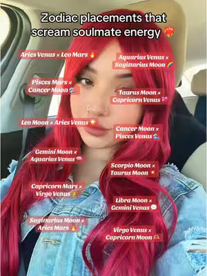 A selfie-style image featuring a woman with long, bright red hair. She is seated in a car, partially visible with the interior in the background. She is looking directly at the camera, with text overlays surrounding parts of her face, pointing out different astrological placements.