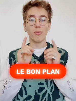 A young man wearing glasses, a sweater vest, and a white shirt is the central focus. He has his fingers pointing up and out on both hands. Below him a red oval announces "LE BON PLAN". The background appears to be a white wall.