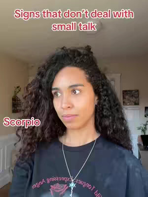 A woman with long, curly dark hair and wearing a black t-shirt is looking off to the side. Text overlays indicate the video's focus on astrological signs.