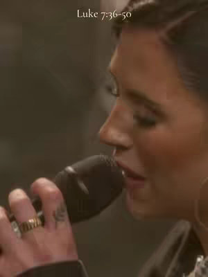 The cover image features a close-up shot of a woman holding a microphone and singing. The photo is warm-toned, the woman's skin has a natural glow. She has a gold ring on her finger. The background is softly blurred. The focus is on the woman's face and the act of singing.