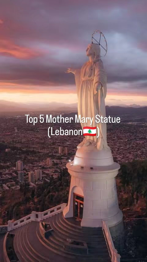 The cover image features a high-angle shot of a towering white statue of the Virgin Mary, set against dramatic sunset colors. The statue stands atop a tall, circular base, with what appears to be a city and mountainous landscape in the background. Wispy clouds and gradients of pink, orange, and purple fill the sky. A simple white text overlay reads the video's title.
