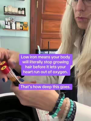 The image shows a woman holding two vials filled with a brown liquid. Text overlays on a purple background provide health-related information. The background is a room with shelves of bottles.