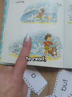 A woman's manicured hand holds a paper depicting a scene of a child and dog playing in the water, with text overlays on the image and in the foreground.