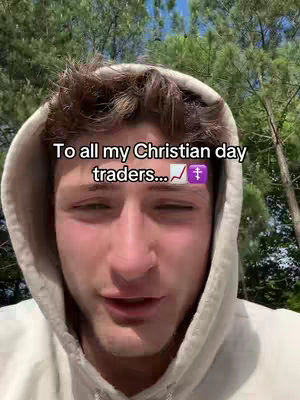 A young man with short brown hair wearing a light gray hoodie smiles and looks directly at the camera. The background is blurred, but shows a lot of green trees. There is an overlay of text with a logo.