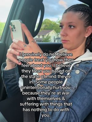 A woman is seated in a car holding a phone, angled towards her face. She has her hair in braids, and her expression is thoughtful as she reads from the phone. The text is overlaid on the image.