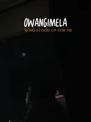 A dark cover image featuring white text overlays. The primary text is "OWANGIMELA" followed by the subtitle "WHO STOOD UP FOR ME." The overall ambiance is dimly lit, suggesting a nighttime setting or a low-light environment. Silhouette of a person is visible in the bottom, adding a human element.