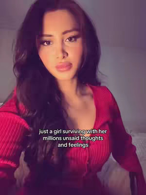 A selfie-style video featuring a young woman in a red top, looking directly at the camera. Text overlay indicates a feeling of unspoken thoughts and emotions.