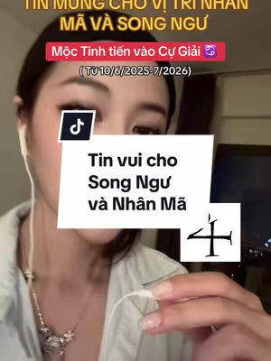 A woman with light skin is in a close-up shot, wearing a light-colored top and white earphones. The image is dominated by text overlays in a white box, with a pink banner that reads, 'Tin vui cho Song Ngu va Nhan Ma'. Behind the text, portions of a background, possibly a room interior are visible, and the woman is looking down at the camera.