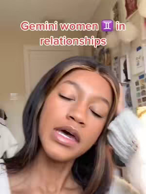 The cover image is a selfie of a young woman with dark hair with light brown highlights, partially closed eyes, positioned slightly off-center. The text overlay says "Gemini women in relationships" in a pinkish-red font. The background includes a door on the left and a wall with items on it.