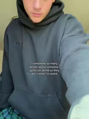 A medium shot shows a young man in a black hoodie, front-facing, looking at the camera. Text in white is overlaid on the image.