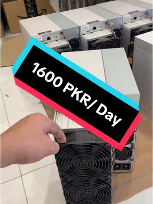 The image shows a close-up view of a Bitcoin mining machine, with a hand touching the front. The machine is mostly black, with a large fan visible. Other machines are visible in the background. Overlaid on the image is a diagonal rectangle with text indicating Pakistani Rupees earned per day.