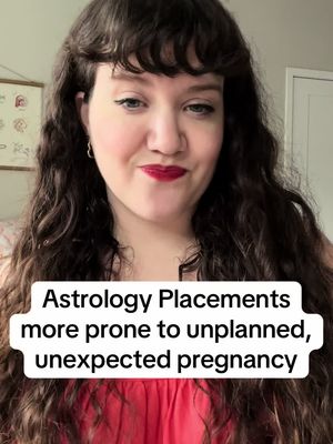 A woman with long wavy dark hair and red lipstick is centered in the frame. She looks down and slightly to the left with a soft smile. A white text box at the bottom reads, "Astrology Placements more prone to unplanned, unexpected pregnancy."