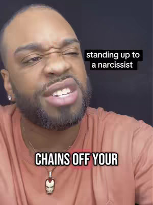 A close-up of a Black man with a serious expression. Text overlays read 'standing up to a narcissist' in a black rectangle and 'CHAINS OFF YOUR' in white with a red glow. He wears a gold necklace with a pendant.
