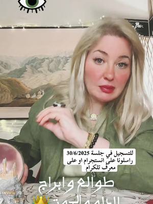 A woman with blonde hair and red lipstick is looking at the camera. She is wearing a green jacket and has several black and gold bracelets on her wrist. In the background is a painting of mountains and sky. The image features overlaid text and a decorative eye-shaped element.
