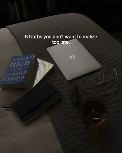 The cover image shows a low angle shot of a bed with various items on it. There is a closed laptop, three books, a journal, glasses, and a glass of tea. The image has a dark and moody aesthetic with dim lighting.