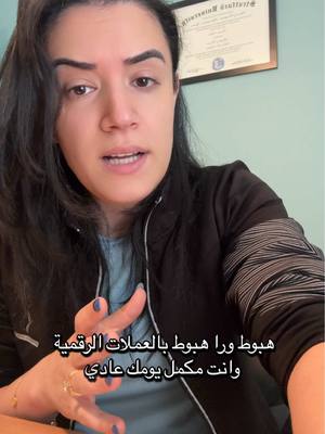 A woman with dark hair is speaking directly to the camera. Behind her is a framed certificate and a teal-colored wall. She's wearing a black jacket over a blue shirt and has rings on her fingers. Text overlays appear at the bottom of the image.