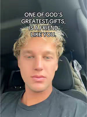 A selfie-style shot featuring a young man with short, styled blonde hair against a backdrop of a car interior. The man is in the frame from his shoulders up and looking at the camera. Overlayed on top is text in a bold white font within a black rectangle. The overall lighting appears to be moderate.