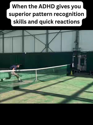 A man plays tennis in a sports hall with a net in the foreground and the text overlay in the top-left corner.