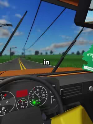 The image is a first-person perspective from inside a vehicle, likely a car or truck. A yellow interior dashboard is in view, with a speedometer and other gauges visible. The steering wheel's lower portion is also present. The windshield is the primary view, looking onto a road that stretches towards the horizon. The sky is blue, with minimal clouds. Text overlayed says 'in'. The overall composition implies a driving scene.