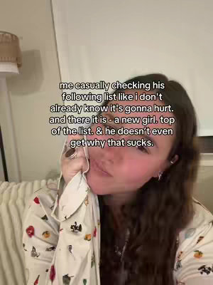 A woman is holding a white and patterned cloth to her face in a selfie-style shot. Text is overlaid on the image, describing the situation. The background includes a portion of a lit lamp and a wall, creating a warm indoor setting.