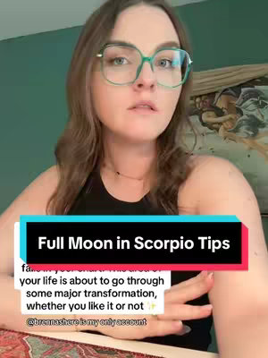 A woman with glasses is framed from the chest up, centered in the frame with a teal wall behind her. The bottom of the shot is overlaid with a red and black banner containing text about full moons.