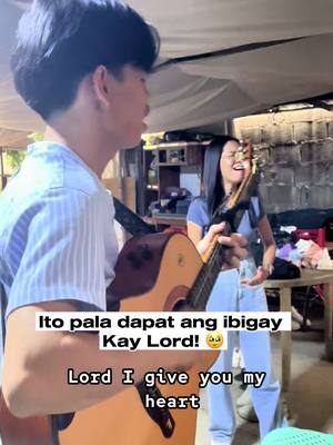 A candid shot shows a young man playing an acoustic guitar on the left with a female companion singing and holding a guitar in the background. Text overlays at the bottom provide context.