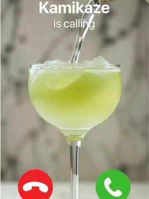 The image shows a cocktail glass filled with a pale green liquid, ice cubes, and the process of being filled. The text overlay has the look of an iPhone interface with the red decline and green accept call buttons at the bottom of the glass.