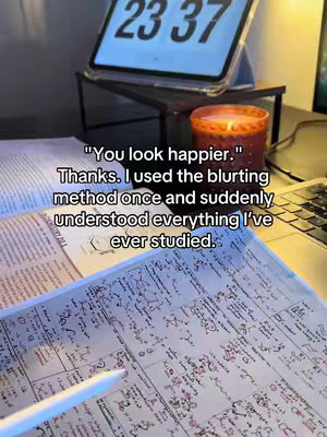The image shows a desk setup with notes, a tablet displaying a clock at 23:37, and a lit candle. Adjacent to the tablet is a notebook and a pen. The text overlay provides context for a study method.