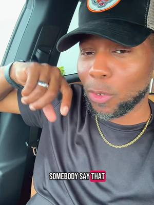 A man in a black shirt and a baseball cap is sitting in a car pointing at the camera, a text overlay at the bottom of the screen says "SOMEBODY SAY THAT"