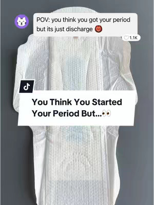 A close-up of an extended sanitary pad on a gray background. The pad dominates the frame, featuring a quilted design with distinct zones. Superimposed are two text overlays: the first, near the upper left, presenting a cat emoji and the text, "POV: you think you got your period but its just discharge [hot face emoji]". The second, positioned lower on the pad, reads, "You Think You Started Your Period But...[eyes emoji]"