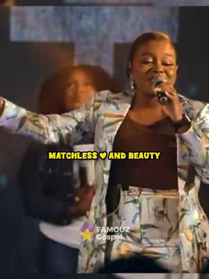 The cover image shows a live performance with a female singer center stage. The singer is wearing a patterned blazer and pants, a black top to match the blazer, and a microphone in hand, with an engaged expression. Behind her is another person partially visible out of focus. The background is dark with stage lighting.