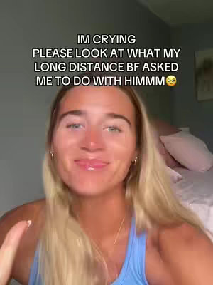 A young woman with blonde hair is centered in the frame, looking at the camera with a slight smile. Text overlays the image, indicating the content relates to a long-distance relationship. The background suggests a bedroom setting with a bed and pillows visible.