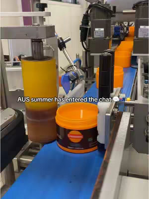 The cover photo shows an industrial setting, likely a manufacturing plant. A conveyor belt moves forward, with a blue surface. On the belt, orange containers are positioned at intervals. Some of the containers and a large, cylindrical yellow object are positioned near the upper left.