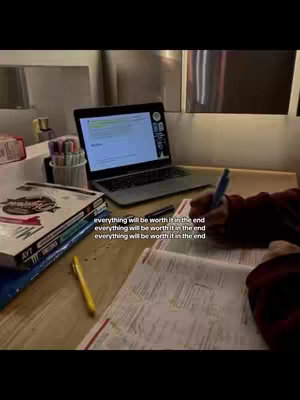 A desk with school supplies and a laptop featuring study notes on the screen. Text overlays read "everything will be worth it in the end". The scene shows a person taking notes on study material in a dimly lit environment emphasizing a studious vibe.