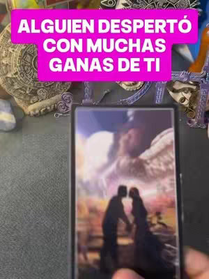 The cover image shows a tarot card held in someone's hand. The card features a couple embracing in silhouette against a blurry backdrop suggesting a sky, perhaps a depiction of a heavenly scene. The card is framed in black, and the background consists of various spiritual objects and accessories, including stones, crystals. A hot pink banner with white text is superimposed at an upper level, and a hand holding an object appears in the foreground.