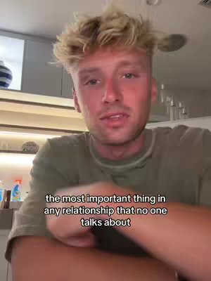 A young man with blonde hair is centered in the frame, looking directly at the camera. The background is a blurred interior with a shelf and a window. Text overlayed at the bottom states, the most important thing in any relationship that no one talks about.