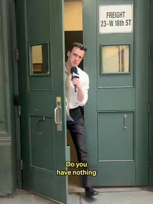 A man in a white shirt and black pants emerges from a green doorway holding a microphone. Text overlayed on the lower part of the image asks, "Do you have nothing."
