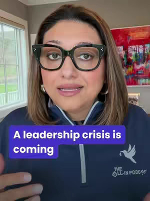 A woman with short brown hair and black glasses looks directly at the camera. She is wearing a blue top, and there's a text overlay on a purple background that reads 'A leadership crisis is coming.' Behind her is a window and a painting.
