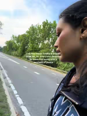 A woman's profile is seen next to a road with text overlaid. Trees and a blue sky are in the background.