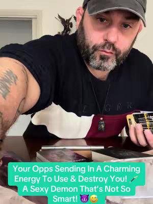 A man with a beard and a dark cap is filming a video at a table. Text is overlaid on the image, with tarot cards in the background.