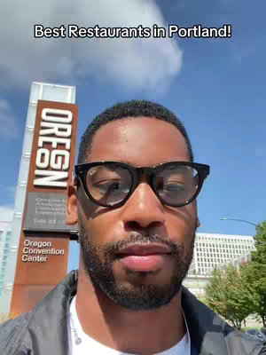 A selfie-style video cover image shows a Black man wearing glasses, standing in front of the Oregon Convention Center sign. The image has the overlay text, "Best Restaurants in Portland!"