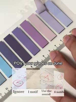The cover image shows a close-up of a hand holding a ruler and colorful sticky notes with some papers with grade markings. There are multi-colored sticky notes. The text overlay reads, "POV: your grades on June".
