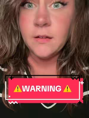 A close-up shot of a woman's face looking directly at the camera, with green eyes that appear to be looking up. The upper half is framed by her wavy, light brown hair and a bold blush on her cheeks, with some makeup. Overlayed on the image is a rectangular bar with the word 'WARNING' in all caps.