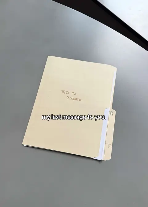 The image shows a tan, rectangular file folder on a gray surface. The folder is slightly open, revealing white paper inside. Handwritten text on the folder says, "THIS IS GOODBYE." Below, overlaid text reads, "my last message to you."