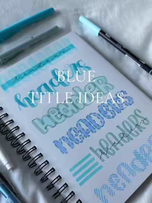 A notebook page with handwritten title ideas in various shades of blue. Text includes the words "Blue Title Ideas" in a playful font, with examples using different styles and coloring techniques.