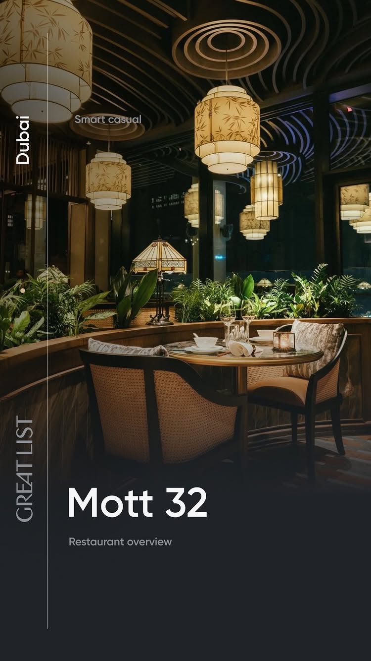 An interior shot of a restaurant with a table set for dining, featuring a lamp, decorative plants, and Asian-style lanterns. The overall composition is dark with a focus on warm, inviting lighting.